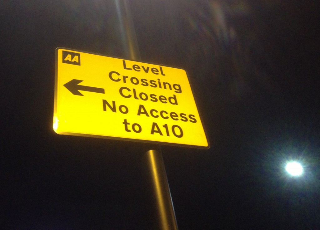 A road sign warns of the closure of the road and pedestrian railway level crossing at Lincoln Road in Enfield, north London. (© London Intelligence)