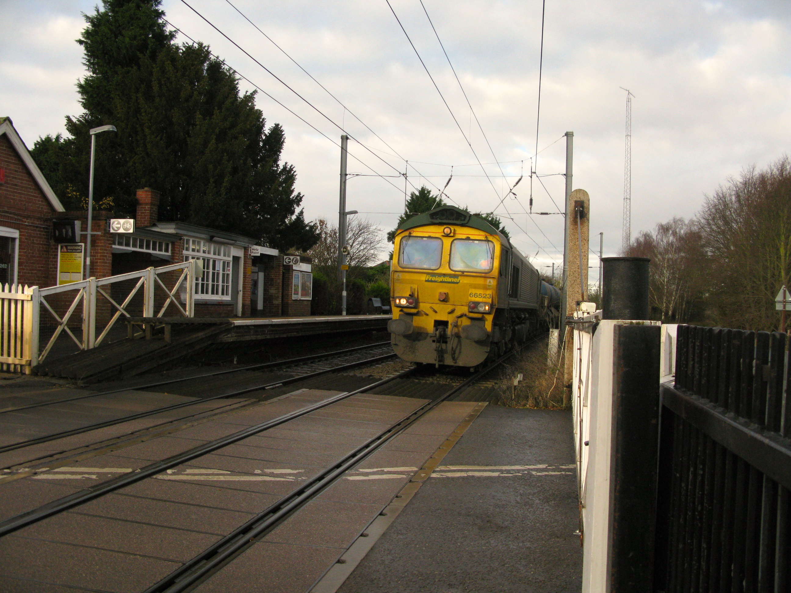 Freightliner 66523 less than a second from the Elsenham level crossings. Black Up side footpath gate on near right (Photo: © London Intelligence)